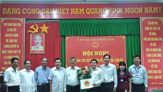 Ông Trương Cảnh Tuyên (giữa) trao quyết định và tặng hoa chúc mừng ông Võ Chí Thắng (thứ tư từ phải qua).